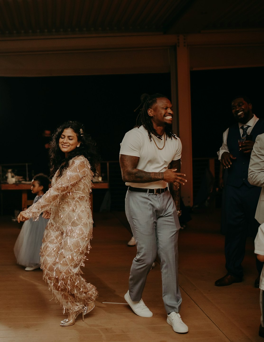 People dance together at an indoor evening celebration.