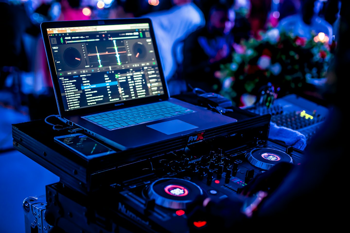 DJ equipment with a hand mixing music at a night event.